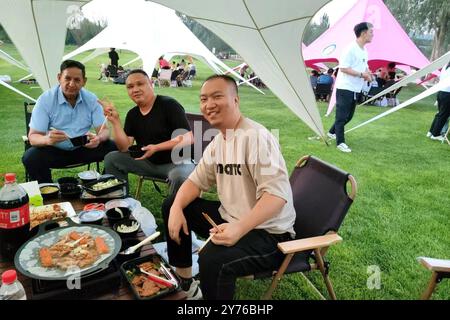 (240928) -- YINCHUAN, 28. September 2024 (Xinhua) -- dieses am 16. August 2024 aufgenommene Foto zeigt Isidro Castaneda Silva (1. L) beim Picknick mit seinen Kollegen in einem Park in Yinchuan, Nordwestchinas autonomer Region Ningxia Hui. Der kubanische Augenarzt Isidro Castaneda Silva kam 2023 nach Yinchuan. Seit er vor mehr als drei Jahrzehnten an einer medizinischen Hochschule in Santiago von Kuba mit einem Doktor abgeschlossen hat, hat Isidro reiche klinische Erfahrung in der Behandlung von häufigen Augenerkrankungen und Fundi-Erkrankungen gesammelt. Neben der Arbeit am AIEr Augenkrankenhaus in Yinchuan bietet Isidro oft kostenlose Klinik Stockfoto