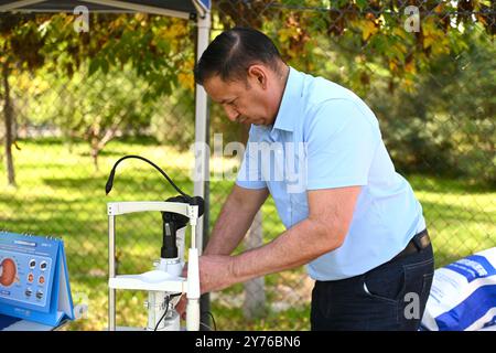 (240928) -- YINCHUAN, 28. September 2024 (Xinhua) -- dieses am 26. September 2024 aufgenommene Foto zeigt Isidro Castaneda Silva, wie er die Ausrüstung vor einer kostenlosen Kliniksitzung in der Gemeinde Jinghu in Yinchuan, Nordwestchinas autonomer Region Ningxia Hui, anpasst. Der kubanische Augenarzt Isidro Castaneda Silva kam 2023 nach Yinchuan. Seit er vor mehr als drei Jahrzehnten an einer medizinischen Hochschule in Santiago von Kuba mit einem Doktor abgeschlossen hat, hat Isidro reiche klinische Erfahrung in der Behandlung von häufigen Augenerkrankungen und Fundi-Erkrankungen gesammelt. Neben der Arbeit am AIEr Augenkrankenhaus in Yinchuan, stellt Isidro oft zur Verfügung Stockfoto