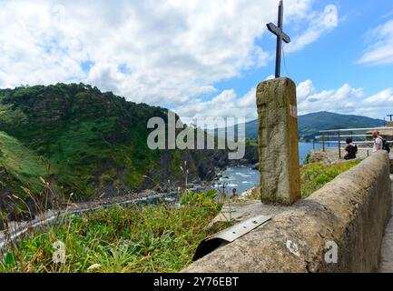 Küste der Bucht von Biskaya mit einem Kreuz vor Bergen und Himmel, in der Nähe der Stadt San Pelaio im Sommer Stockfoto