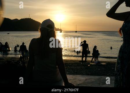Menschen genießen den Sonnenuntergang am Taganga Beach in der Nähe von Santa Marta, Kolumbien Stockfoto