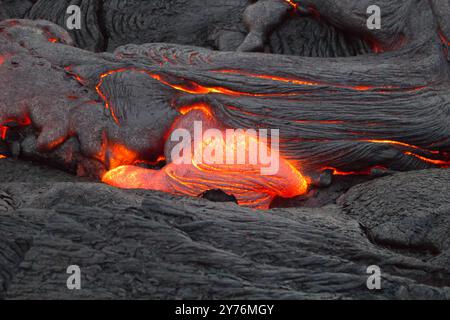 Geschmolzene Lava, die durch Risse fließt Stockfoto