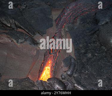 Geschmolzene Lava, die durch Risse fließt Stockfoto