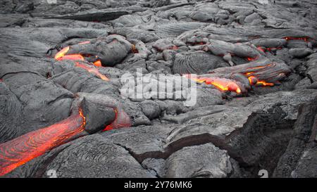 Geschmolzene Lava, die durch Risse fließt Stockfoto