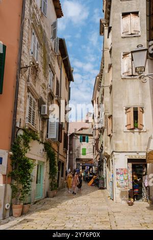 Rovinj Kroatien 27. August 2024 schlendern Sie durch Rovinjs enge kopfsteingepflasterte Gassen, die von farbenfrohen Gebäuden und lebhaften Geschäften gesäumt sind. Besucher können diese malerische Küstenstadt erkunden. Stockfoto