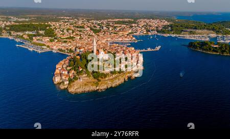 Rovinj Kroatien lebendige Landschaft erwacht von oben mit bezaubernder mediterraner Architektur auf einer felsigen Halbinsel. Sonnendurchflutetes Wasser umrahmt die malerische Stadt mit Blick auf die Drohne Stockfoto