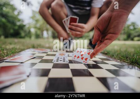 Spielen Sie Karten auf einem Schachbrett im Park Stockfoto