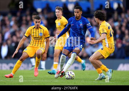 Chelsea's Levi Colwill (Mitte) kämpft um den Ball mit Yasin Ayari von Brighton und Hove Albion (links) und Ferdi Kadioglu während des Premier League-Spiels in Stamford Bridge, London. Bilddatum: Samstag, 28. September 2024. Stockfoto