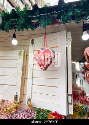 Traditionelle Gerichte zum Verkauf am Verkaufsstand auf dem Weihnachtsmarkt. Weihnachtsmarkt. Holzkiosk mit Weihnachtsdekorationen und Süßigkeiten Stockfoto