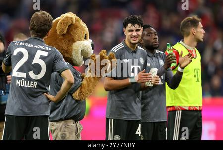 MÜNCHEN - 28. SEPTEMBER: Thomas Mueller von Bayern München, Aleksandar Pavlovic von Bayern München und Mascot Bernie mit Lederhosen feiern mit den Fans nach dem Bundesliga-Spiel zwischen dem FC Bayern München und Bayer 04 Leverkusen am 28. September 2024 in München. © diebilderwelt / Alamy Live News Stockfoto