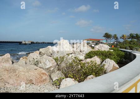 Eine zeitgenössische Promenade, gesäumt von weißen Felsen, schmückt die Uferpromenade und lädt Touristen zur Karibikinsel Curacao in der Stadt Willemstad ein. Stockfoto