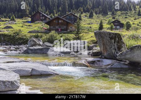 Wildbach rein da Christallina bei Medel. Chalet, Holzhaus im typisch Schweizer Stil. Medel, Kanton Graubünden, Schweiz, Europa Stockfoto