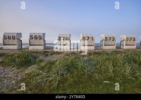Weiße Liegestühle und Strandgras am Abend am Strand in Hooksiel, Wangerland, Landkreis Friesland, Niedersachsen, Deutschland, Europa Stockfoto