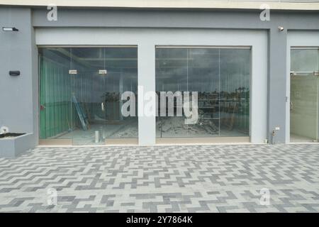 Ein Geschäft oder Restaurant mit großen Glasfenstern wird derzeit an einer Hauptstraße in Oranjestad, Aruba, einer karibischen Insel, renoviert. Stockfoto