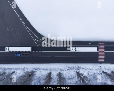 Zwei Lastwagen auf der Straße Blick aus der Luft im Winter Stockfoto