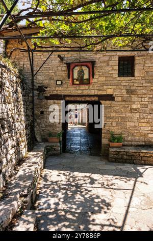 Steineingang zum Kloster Agia Paraskevi in Monodendri, Griechenland, mit traditioneller Architektur und dem Wahrzeichen des heiligen Paraskevi. Stockfoto