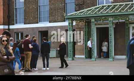 London, England, 10. Mai 2023: Menschen, die sich anstellen, um den Kensington Palace zu betreten und ihn zu besuchen, da er ein sehr beliebter Ort für Touristen in London ist Stockfoto