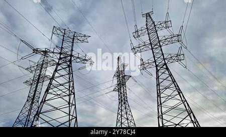 Mehrere Hochspannungsleitungen gegen bewölkten Himmel. Stockfoto