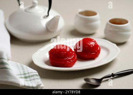 Angku Kue Thok Rote Schildkröte Kuchen mit Mungbohnen Paste Füllung, beliebt als Kue Thok. Serviert mit Tee Stockfoto