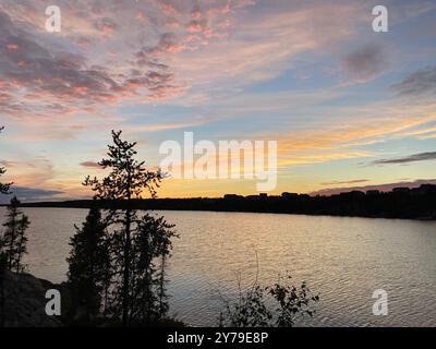 Wunderschöner Sonnenuntergang über borealen arktischen Bäumen und einem See in der Nähe von Yellowknife, Northwest Territories, Kanada Stockfoto