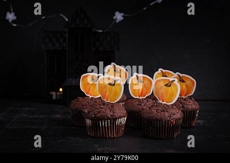 Festliche Halloween-Cupcakes und Leckereien, die mit lustigen Aufklebern dekoriert sind. Halloween Muffins. Schokoladenmuffins Stockfoto