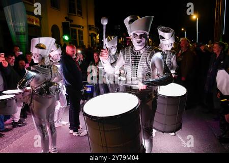 Weymouth, Dorset, Großbritannien. September 2024. Worldbeaters Drummers präsentieren die Weltpremiere ihrer neuen Show Glühwürmchen beim Dusk Til Dark Festival in Weymouth in Dorset. Eine riesige Menschenmenge säumte die Esplanade, um die Show mit ihrer Fusion aus Trommeln, Licht und Community-Performern zu beobachten, während sie sich durch die vielen Hundert Zuschauer schlängelte, die die Straße von der Königsstatue bis zu ihrem Ziel im Weymouth Pavilion säumten. Bildnachweis: Graham Hunt/Alamy Live News Stockfoto