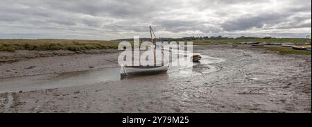 Ein Weitwinkelblick auf den Morston Quay in Norfolk. Die Flut ist vorbei und die kleinen Boote liegen am Ufer. Stockfoto