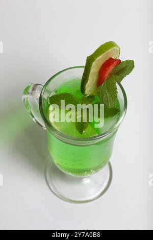 Grüne Limonade im Glas. Dekoriert mit Limette und Erdbeeren. Mit Minzzweigen. Stockfoto