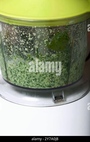 Spinat und Minze in einem Mixbecher zum Zerkleinern. Für die Herstellung von Keksrollen mit Spinat und Minze. Mit Erdbeeren gefüllt. Zutaten zum Kochen. Stockfoto