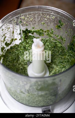 Spinat und Minze in einem Mixbecher zum Zerkleinern. Zum Zubereiten von Keksrollen mit Spinat und Minze. Mit Erdbeeren gefüllt. Zutaten zum Kochen. Stockfoto
