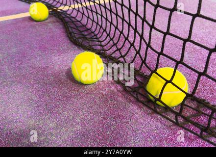 Ball im Schatten des Netzes eines blauen Paddle-Tennisplatzes. Stockfoto