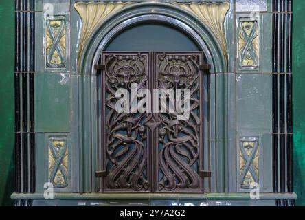 Die Tür eines alten Ofens, in den Feuerholz gelegt wurde. Stockfoto