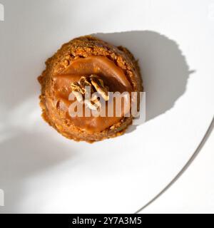 Kuchen Sie einen Korb mit Schokoladenkondensmilch und Nüssen auf weißem Hintergrund. Stockfoto