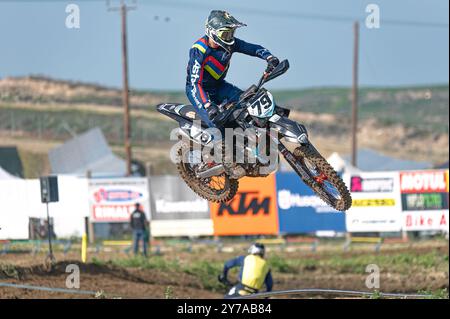 Agios Sozomenos, Zypern – 11. Februar 2024: Motocross-Fahrer tragend Schutzausrüstung beim Hochsprung mit seinem Geländemotorrad während eines Motos Stockfoto