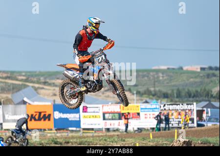 Agios Sozomenos, Zypern - 11. Februar 2024: Motocross-Fahrer tragen Schutzausrüstung und fahren mit einem Dirt Bike, während sie während eines Motocros durch die Luft fliegen Stockfoto