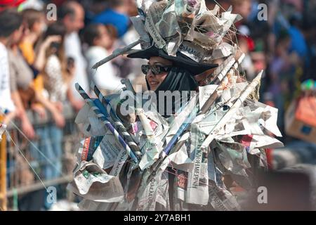 Limassol, Zypern - 26. März 2023: Die junge Frau lächelt, während sie ein Kostüm aus Zeitung trägt und an einer Limassol-Karnevalsparade teilnimmt Stockfoto