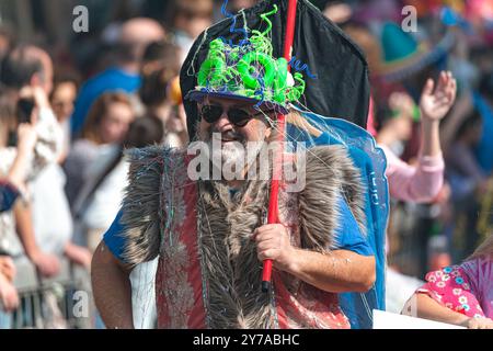 Limassol, Zypern - 26. März 2023: Lächelnder bärtiger Mann, der ein farbenfrohes Kostüm trägt, während einer Karnevalsparade auf der Straße spaziert Stockfoto