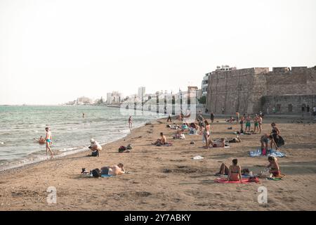 Larnaca, Zypern - 07. September 2019: Touristen entspannen und schwimmen an einem überfüllten Strand von Finikoudes in der Nähe der Burg Larnaca Stockfoto