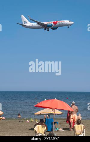 Larnaca, Zypern - 17. Juli 2022: Flugzeug der AirExplore Airlines fliegt über Touristen, die sich am McKenzie Beach entspannen Stockfoto