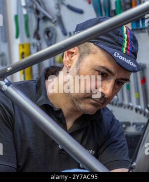 Männlicher Fahrradmechaniker in einer Werkstatt repariert ein Fahrrad, London, Großbritannien Stockfoto