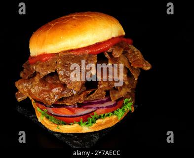 Döner-Kebab-Fleisch-Sandwich in einem Brioche-Brötchen mit frischem Salat und Tomatensauce Stockfoto
