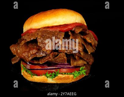 Döner-Kebab-Fleisch-Sandwich in einem Brioche-Brötchen mit frischem Salat und Tomatensauce Stockfoto