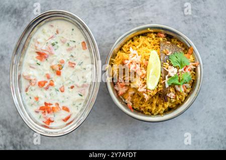 Würziger indischer Biryani-Pulao in goldener Schüssel mit indischem Basmati-Reisgericht mit Hühnerfleisch-Curry Ramadan Kareem, Eid. Servierschale aus Messing mit weißem Rücken Stockfoto