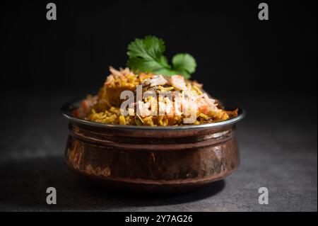 Würziger indischer Biryani-Pulao in goldener Schüssel mit indischem Basmati-Reisgericht mit Hühnerfleisch-Curry Ramadan Kareem, Eid. Servierschale aus Messing mit weißem Rücken Stockfoto