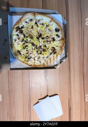 Pizza in einer Kiste auf dem Tisch Stockfoto