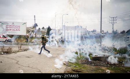 Palästinensische Demonstranten werfen Steine auf die israelischen Truppen während Zusammenstößen mit den israelischen Sicherheitskräften in der Nähe der jüdischen Siedlung Beit El, am Rande der Stadt Ramallah im Westjordanland. Die Auseinandersetzungen folgten einem Protest gegen den Besuch des US-Vizepräsidenten Mike Pence in Jerusalem Stockfoto