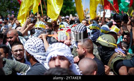 Birzeit, Westjordanland, Palästina. Juni 2021. Während der Beerdigung des Birzeit-Universitätsstudenten Fadi Wahha in Birzeit, nördlich von Ramallah, werden palästinensische Flaggen sowie Flaggen verschiedener palästinensischer Widerstandskräfte gehisst. Fadi starb, nachdem er seinen Wunden erlag, die er erlitten hatte, als er von israelischen Truppen während eines Protestes gegen die israelische Besatzung und den israelischen Bombardements auf Gaza am 15. Mai in der Stadt Al-Bireh im Westjordanland, dem Nakba-Tag, in den Kopf geschossen wurde. Nach lokalen Quellen blutete der 34-jährige Palästinenser stark, nachdem er erschossen worden war und wurde nur zum i gebracht Stockfoto