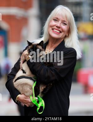 Holly Hennessy mit ihrer Siamkatze Captain im Europa Hotel in Belfast, die beide seit vier Monaten in Belfast festsitzen, während der Verzögerungen bei der Abfahrt des Kreuzfahrtschiffes Villa Vie Odyssey. Foto Datum: Samstag, 28. September 2024. Stockfoto