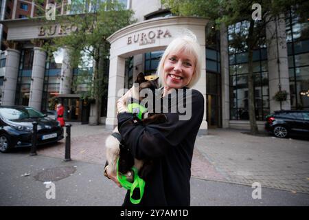 Holly Hennessy mit ihrer Siamkatze Captain im Europa Hotel in Belfast, die beide seit vier Monaten in Belfast festsitzen, während der Verzögerungen bei der Abfahrt des Kreuzfahrtschiffes Villa Vie Odyssey. Foto Datum: Samstag, 28. September 2024. Stockfoto