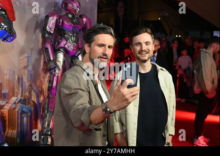 Schauspieler Tom Beck spricht Anführer von Cybertron Sentinel Prime , l-r, und Comedian Phil Laude spricht Autobot B-127 alias Bumblebee posiert als deutsche Synchronstimme beim Special Screening des Animationsfilms Transformers One , das jüngste Kapitel der Robo-Alien-Saga, gestartet am 10. Oktober 2024 in den deutschen Kinos *** Schauspieler Tom Beck Stimme Anführer von Cybertron Sentinel Prime , l r, und Komiker Phil Laude Stimmen Autobot B 127 aka Bumblebee posiert als deutsche Synchronstimme bei der Sondervorführung des Zeichentrickfilms Transformers One , das letzte Kapitel der Robo Alien Saga eröffnet Stockfoto