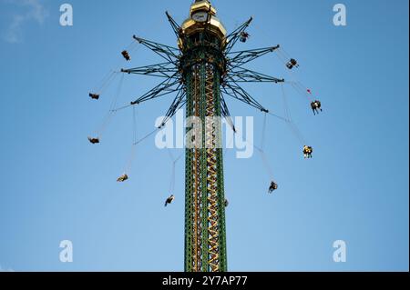 Riesenfähren fahren mit Menschen in einem Vergnügungspark. Heller, sonniger Tag für Unterhaltung. Kopierraum. Stockfoto
